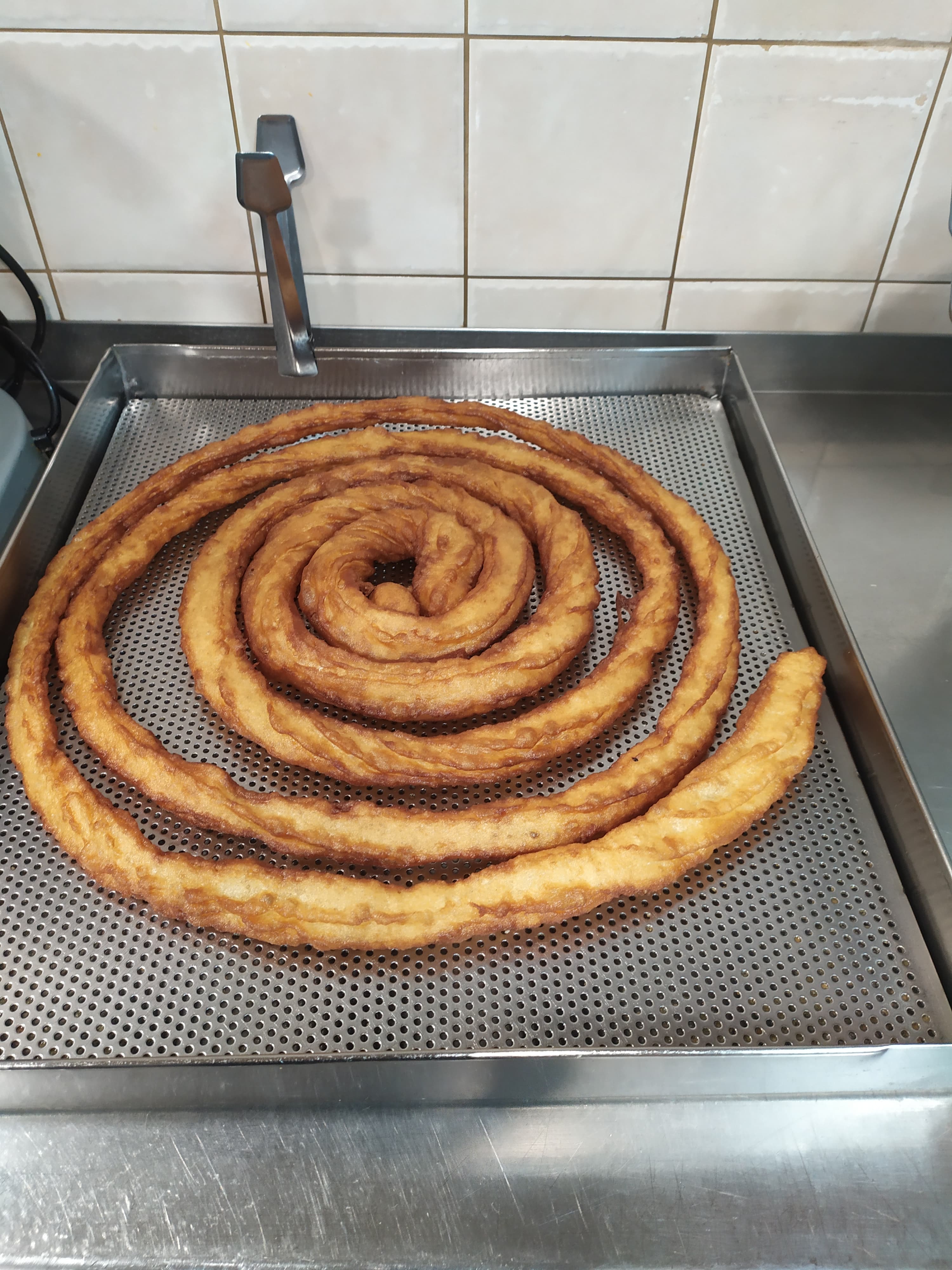 Porra en espiral sobre el escurridor — Churrería Susi