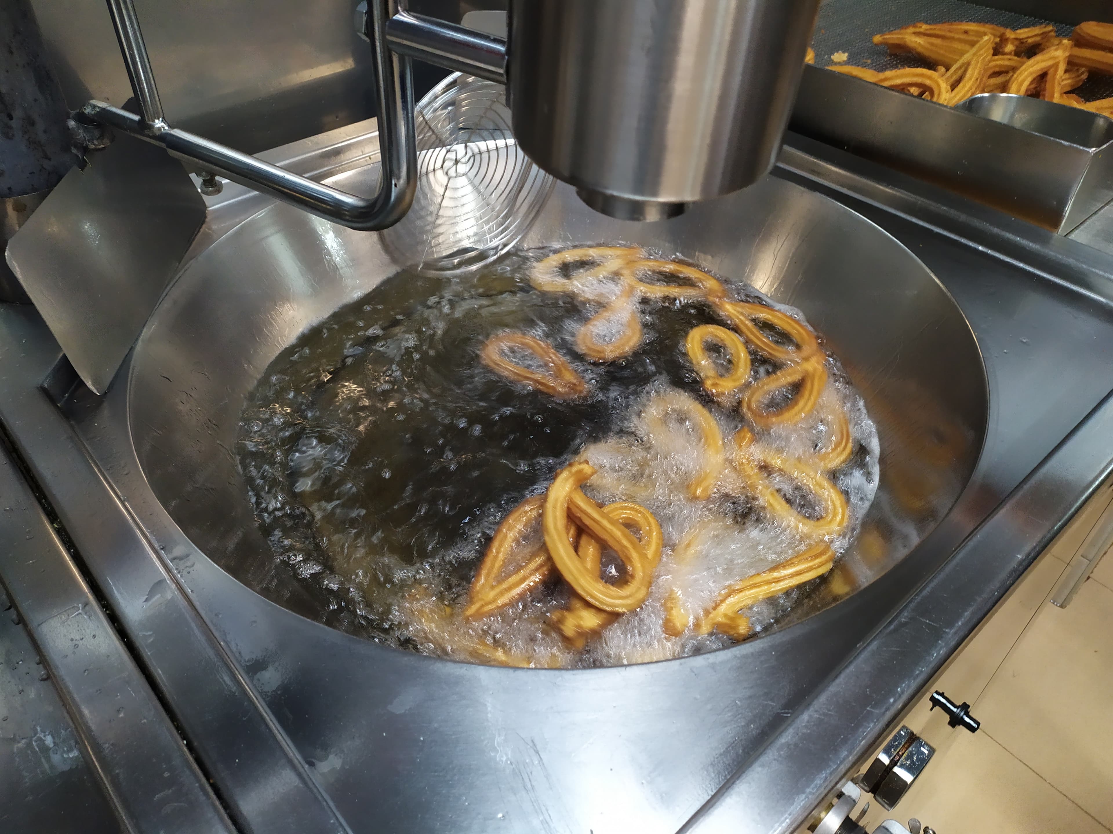 Churros friéndose en aceite caliente — Churrería Susi